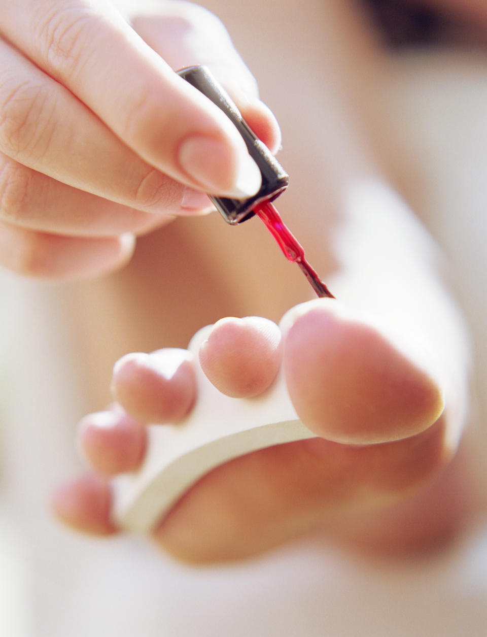 Close-up of a person applying nail polish to toenails