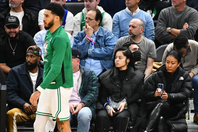 <p> Allen Berezovsky/Getty</p> Ella Mai sitting courtside at a Boston Celtics game while Jayson Tatum plays in 2022