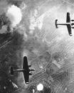 Two German Dornier 217 planes pass over the burning bombing targets of the Beckton Gas Works at Silvertown, a suburb in the southeast of London, during the Battle of Britain in autumn 1940.