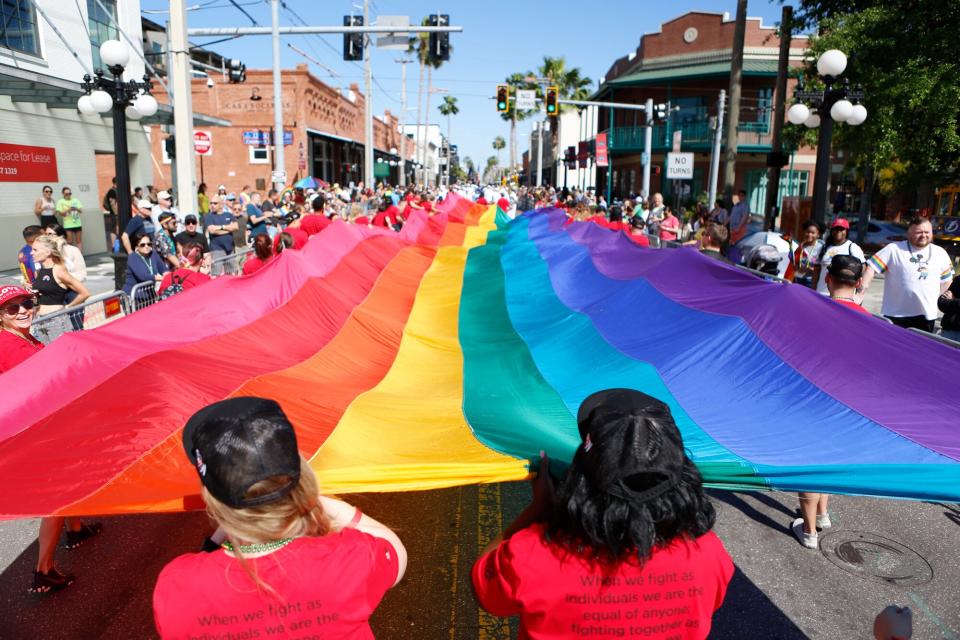 Revelers celebrate on the 7th Avenue during the Tampa Pride Parade in the Ybor City neighborhood on March 26, 2022 in Tampa, Florida. The Tampa Pride was held in the wake of the passage of Florida's controversial "Don't Say Gay" Bill.