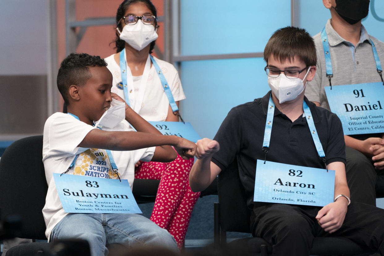 Sulayman Abdirahman, 12, from Roxbury, Mass., left, gets a fist bump from Aaron Kuebler, 12, from Oviedo, Fla., after Abdirahman succeeded to the next round, while competing during the Scripps National Spelling Bee, in Oxon Hill, Md., Tuesday, May 31, 2022. (AP Photo/Jacquelyn Martin)