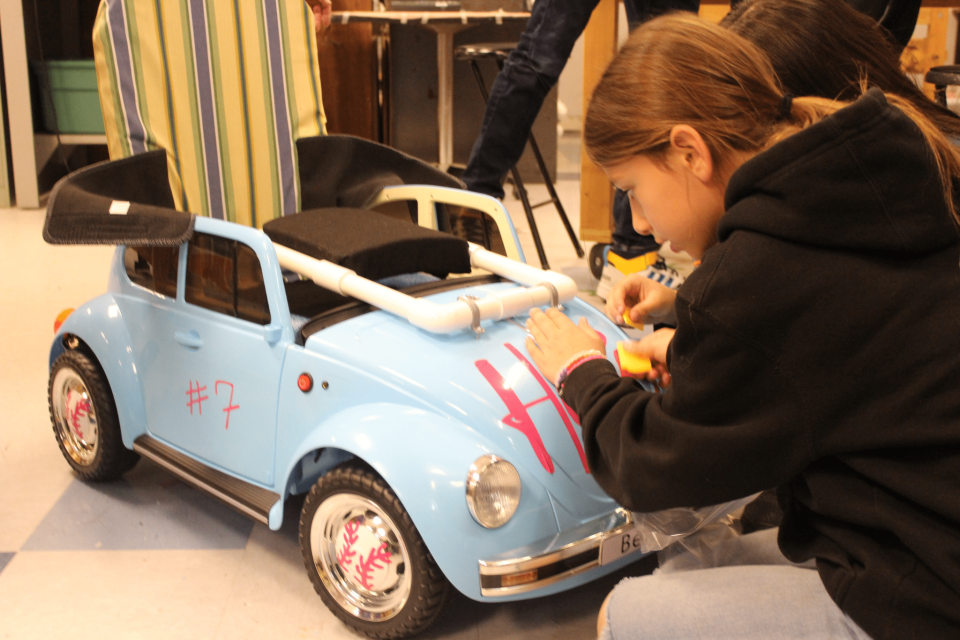Chayce Dye, student at Lynn Community Middle School, applies final decals to the finished mobility car intended for an elementary student with Trisomy 18 at Cruces Creatives in Las Cruces on Friday, April 8, 2022.