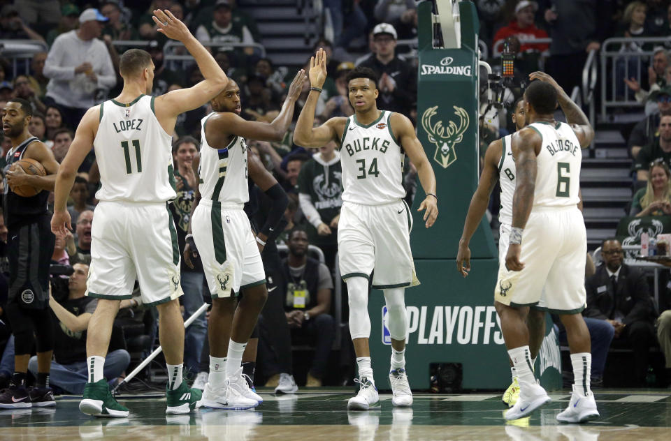 Milwaukee Bucks' Giannis Antetokounmpo gives high-fives to his teammates during the first half of Game 2 of an NBA basketball first-round playoff series against the Detroit Pistons on Wednesday, April 17, 2019, in Milwaukee. (AP Photo/Aaron Gash)