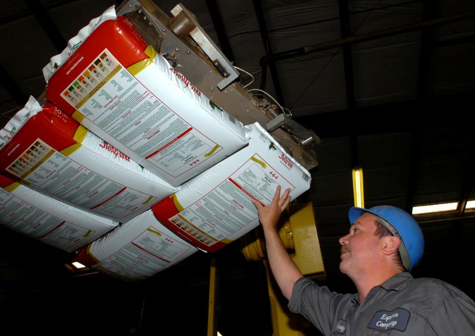 Marty O'Neill, production manager at the Espoma Company in Millville, checks a pallet of tomato fertilizer as it is carried by an arm of an APS Robotics machine in this 2008 photo.