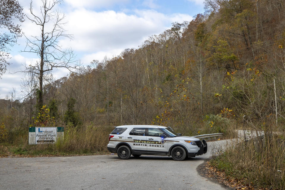 A sheriff's vehicle blocks a road leading to the area where a rescue operation is underway for two workers trapped inside a collapsed coal preparation plant in Martin County, south of Inez, Ky., on Wednesday, Nov. 1, 2023. Kentucky Gov. Andy Beshear says a man has died after he and a coworker were trapped beneath a collapsed 11-story building being demolished at an abandoned mine’s coal preparation plant. (Ryan C. Hermens/Lexington Herald-Leader via AP)