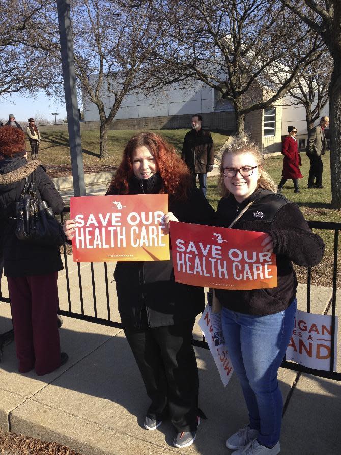 Britt Waligorski, 31, and Mary Whitfield, 18, attend an Affordable Health Act rally on Sunday, Jan. 15, 2016, in Warren, Mich. Thousands of people showed up in freezing temperatures on Sunday in Michigan where Sen. Bernie Sanders called on Americans to resist Republican efforts to repeal President Barack Obama's health care law, one of a number of rallies Democrats staged across the country to highlight opposition. (AP Photo/Corey Williams)