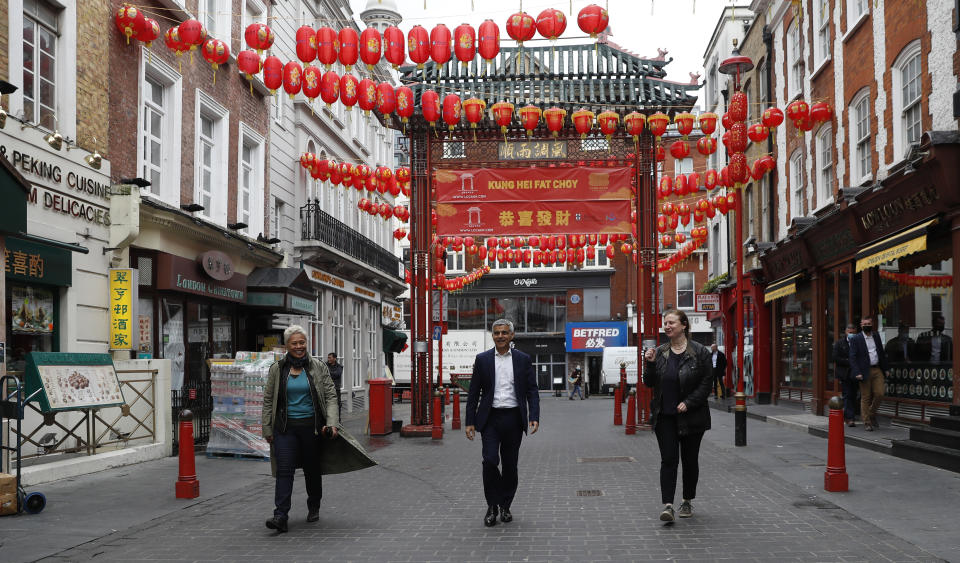 Mayor of London Sadiq Khan, centre, with chefs Angela Hartnett, right and Monica Galetti, walks in China Town central London, Monday, May 17, 2021. Pubs and restaurants across much of the U.K. are opening for indoor service for the first time since early January even as the prime minister urged people to be cautious amid the spread of a more contagious COVID-19 variant. (AP Photo/Alastair Grant)