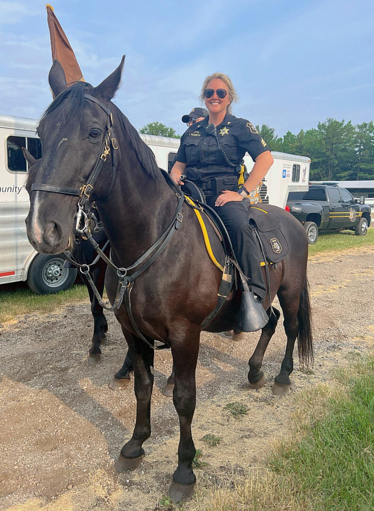 Sgt. Lacey Polderdyke, of the Internal Affairs Section Honor Guard Mounted Unit for Wayne County Sheriff's Office, on the horse she rides, Hogan, at the Midwest Invitational Black Rodeo on June 10, 2023, in Belleville. Polderdyke pushed for service horses to be included for interment at the Michigan War Dog Memorial cemetery in Lyon Township.