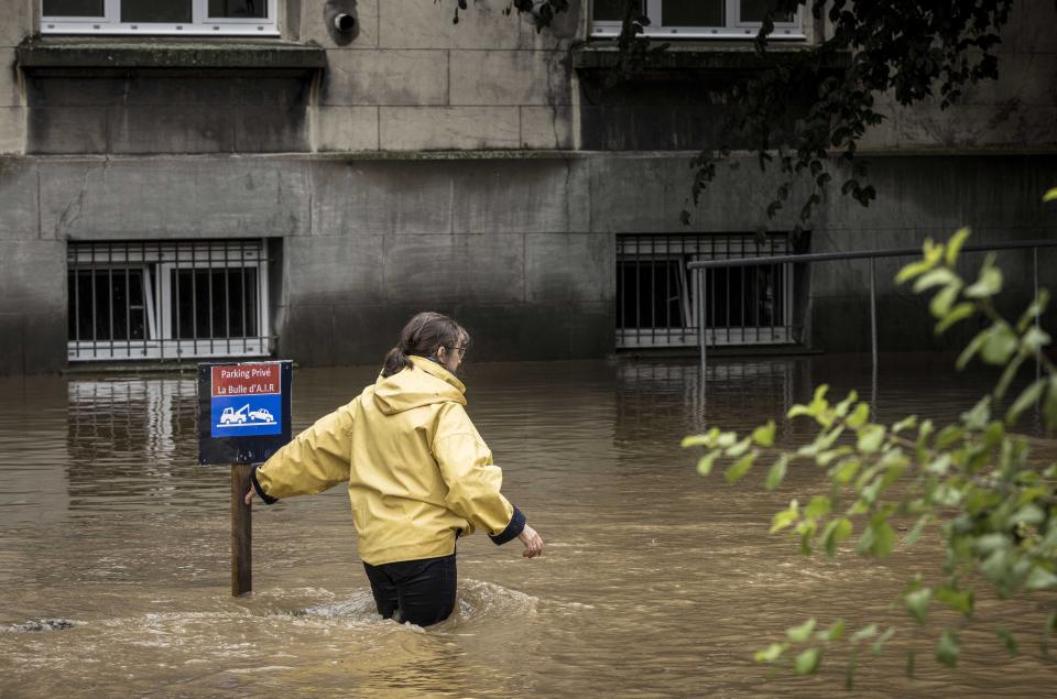 A woman braves the floodwaters in Liège, Belgium on Thursday.