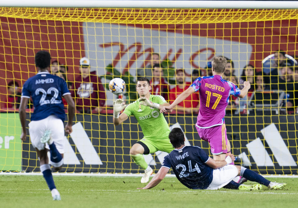 Toronto FC goalkeeper Tomás Romero, center, blocks a shot by Vancouver Whitecaps forward Brian White (24) during second-half MLS soccer match action in Toronto, Saturday, Sept. 16, 2023. (Spencer Colby/The Canadian Press via AP)