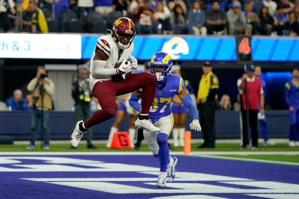 Washington Commanders wide receiver Curtis Samuel, left, makes a touchdown catch over Los Angeles Rams safety Quentin Lake (37) during the second half of an NFL football game Sunday, Dec. 17, 2023, in Los Angeles. (AP Photo/Ryan Sun)