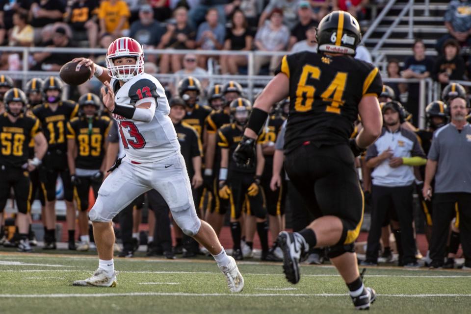 Sheridan quarterback Caden Sheridan looks for a receiver as Watkins Memorial's Colton Rhoades pressures during the visiting Generals' 24-19 win at Ascena Field on Friday, Aug. 25, 2023.