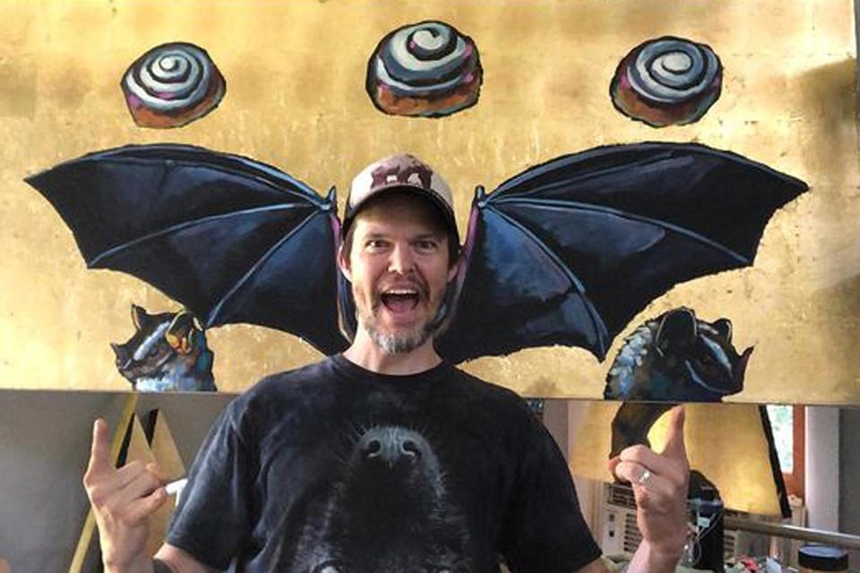 Athens artist Will Eskridge poses in his studio with his painting "We Sold Our Souls For Cinnamon Rolls."