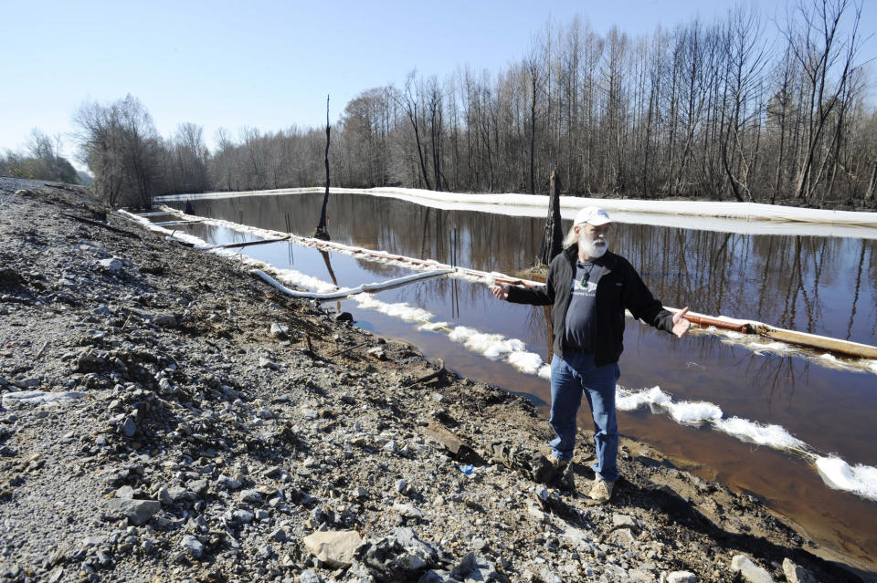 John Wathen, an environmentalist with the Waterkeeper Alliance, gestures at the site of a train derailment and oil spill near Aliceville, Ala., on Wednesday, May 5, 2014. Environmental regultors say cleanup and containment work is continuing at the site, but critics contend the accident and others show the danger of transporting large amounts of oil in tanker trains. (AP Photo/Jay Reeves)
