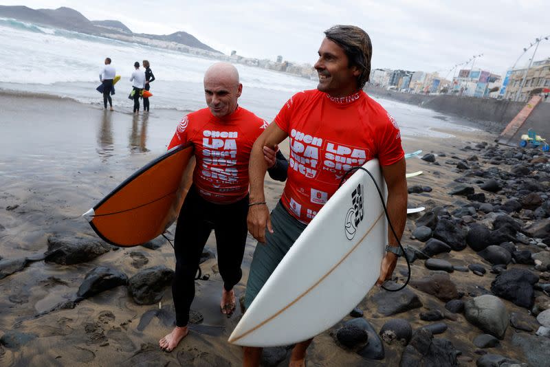 Surfer Aitor Francesena, adapted surfing world champion, who was born with congenital glaucoma, is helped by his assistant after finishing the adaptive surfing competition in Las Palmas de Gran Canaria