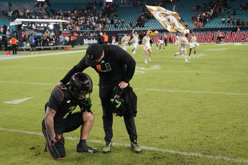 Miami wide receiver Xavier Restrepo is consoled after Georgia Tech beat Miami 23-20 during an NCAA college football game, Saturday, Oct. 7, 2023, in Miami Gardens, Fla. (AP Photo/Wilfredo Lee)