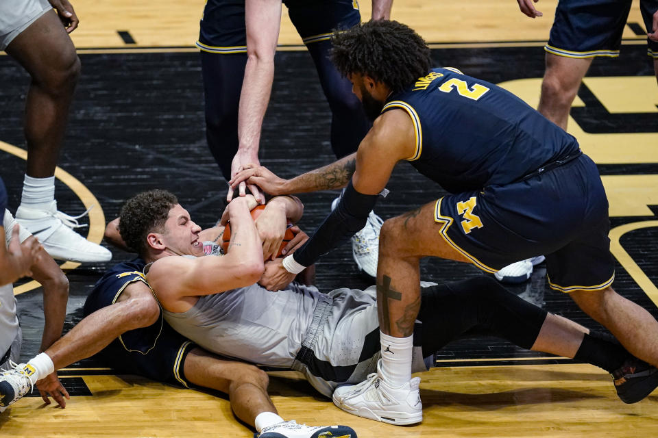 Purdue forward Mason Gillis (0) and Michigan forward Isaiah Livers (2) try to get possession of the ball during the second half of an NCAA college basketball game in West Lafayette, Ind., Friday, Jan. 22, 2021. (AP Photo/Michael Conroy)