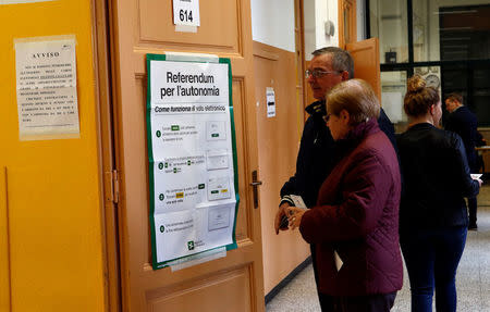 Residents arrive to cast their electronic votes for the Lombardy's autonomy referendum at a polling station in Milan, Italy, October 22, 2017. REUTERS/Alessandro Garofalo