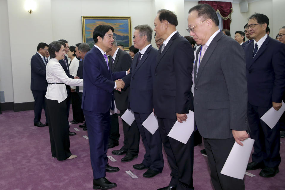 In this photo released by the Taipei News Photographer, Taiwan's new President Lai Ching-te, center left, and Vice President Hsiao Bi-khim, second left, shake hands with ministers after Lai's inauguration ceremonies in Taipei, Taiwan, Monday, May 20, 2024. Lai was sworn in as Taiwan's new president Monday, beginning a term in which he is expected to continue the self-governing island's policy of de facto independence from China while seeking to bolster its defenses against Beijing. (Taipei News Photographer via AP)