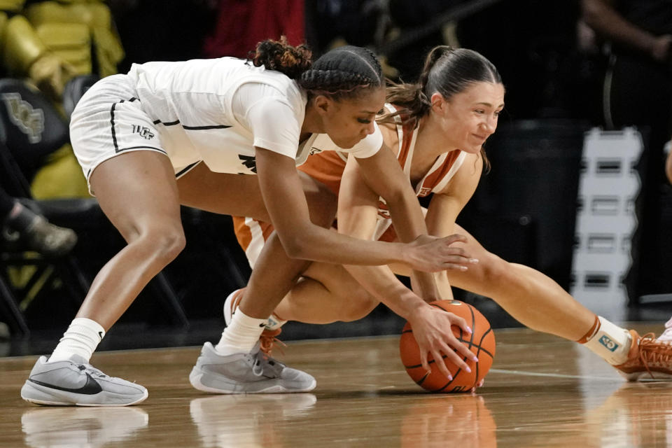 Central Florida guard Mya Burns, left, and Texas guard Shay Holle battle for a loose ball during the second half of an NCAA college basketball game, Saturday, Feb. 24, 2024, in Orlando, Fla. (AP Photo/John Raoux)