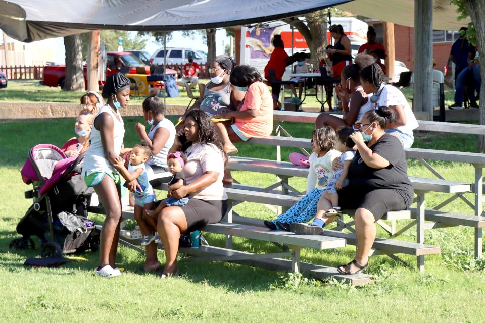 Families wait their turn during a previous Braids and Fades event, which gathers volunteer hair stylists and barbers to give free hair cuts and braids to students before school.