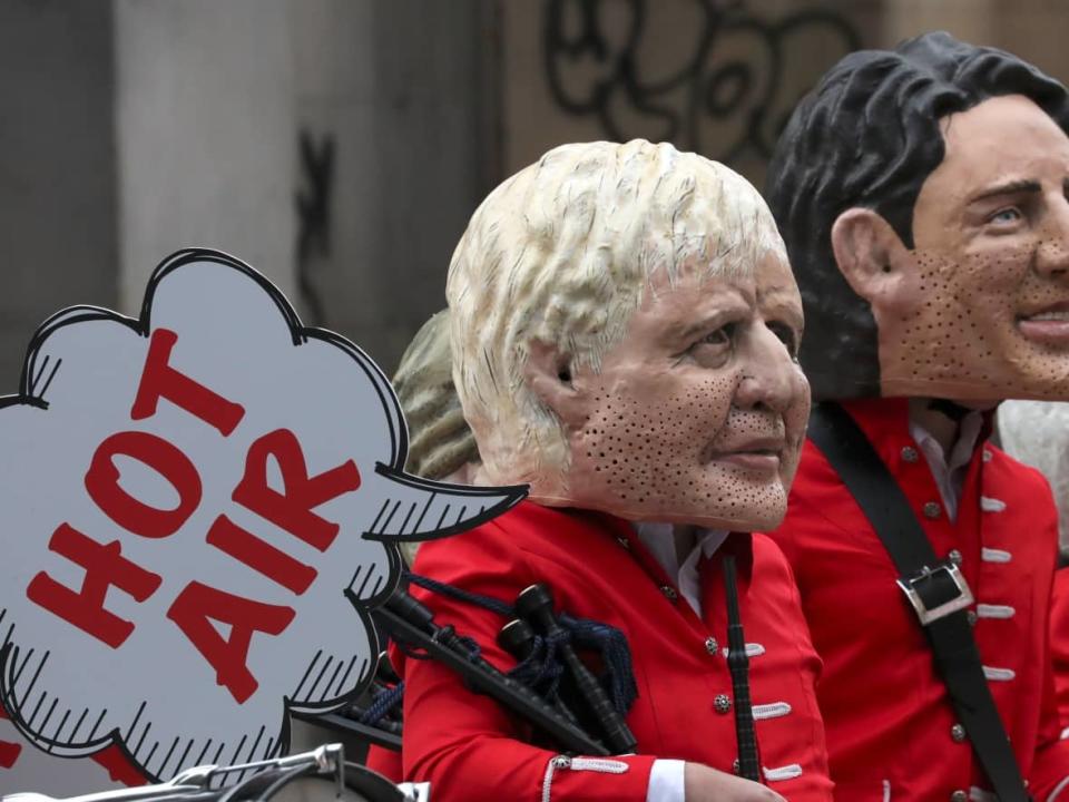 So-called big head caricatures of world leaders Boris Johnson and Justin Trudeau were on display at a protest outside the COP26 climate summit in Glasgow, Scotland, on Nov. 1. The UN-organized meeting gathers leaders from around the world to agree on parameters for tackling global warming. (Scott Heppell/Associated Press - image credit)