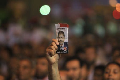 A supporter of Mohammed Mursi holds a leaflet depicting Mohammed Mursi during a campaign rally in Cairo on May 20. Initial results of expatriate voting showed Muslim Brotherhood candidate Mursi leading the race thanks to massive support from the Egyptian community in Saudi Arabia