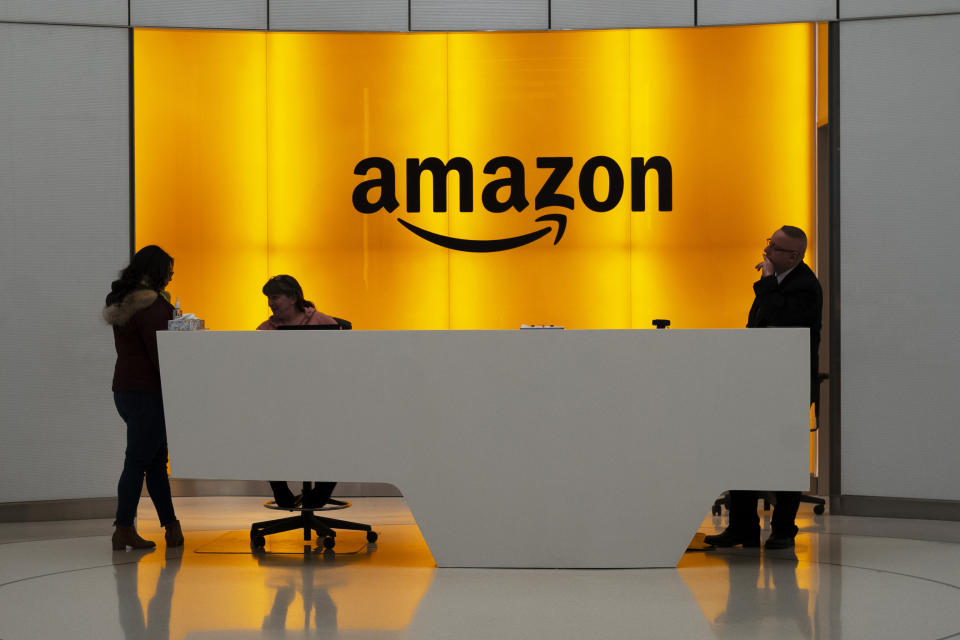 FILE - In this Feb. 14, 2019, file photo people stand in the lobby for Amazon offices in New York. Amazon and Microsoft are battling for a $10 billion opportunity to build the U.S. military its first “war cloud.” (AP Photo/Mark Lennihan, File)