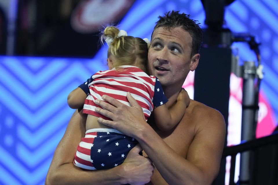 Ryan Lochte holds his daughter after his heat in the men's 200 Individual Medley during wave 2 of the U.S. Olympic Swim Trials on Thursday, June 17, 2021, in Omaha, Neb. (AP Photo/Charlie Neibergall)