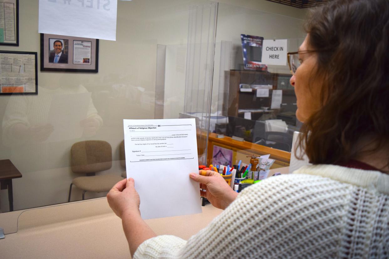 Holmes County Board of Elections Director Lisa Welch looks over the affidavit available for voters who do not have a photo ID because of religious beliefs.