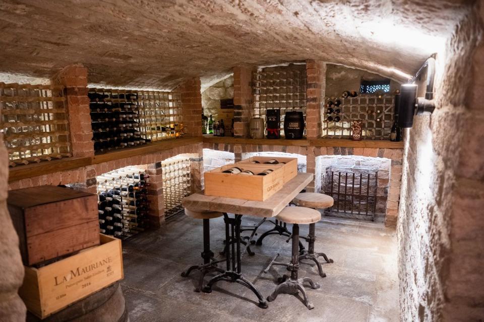 a cellar with a table and shelves full of wine bottles