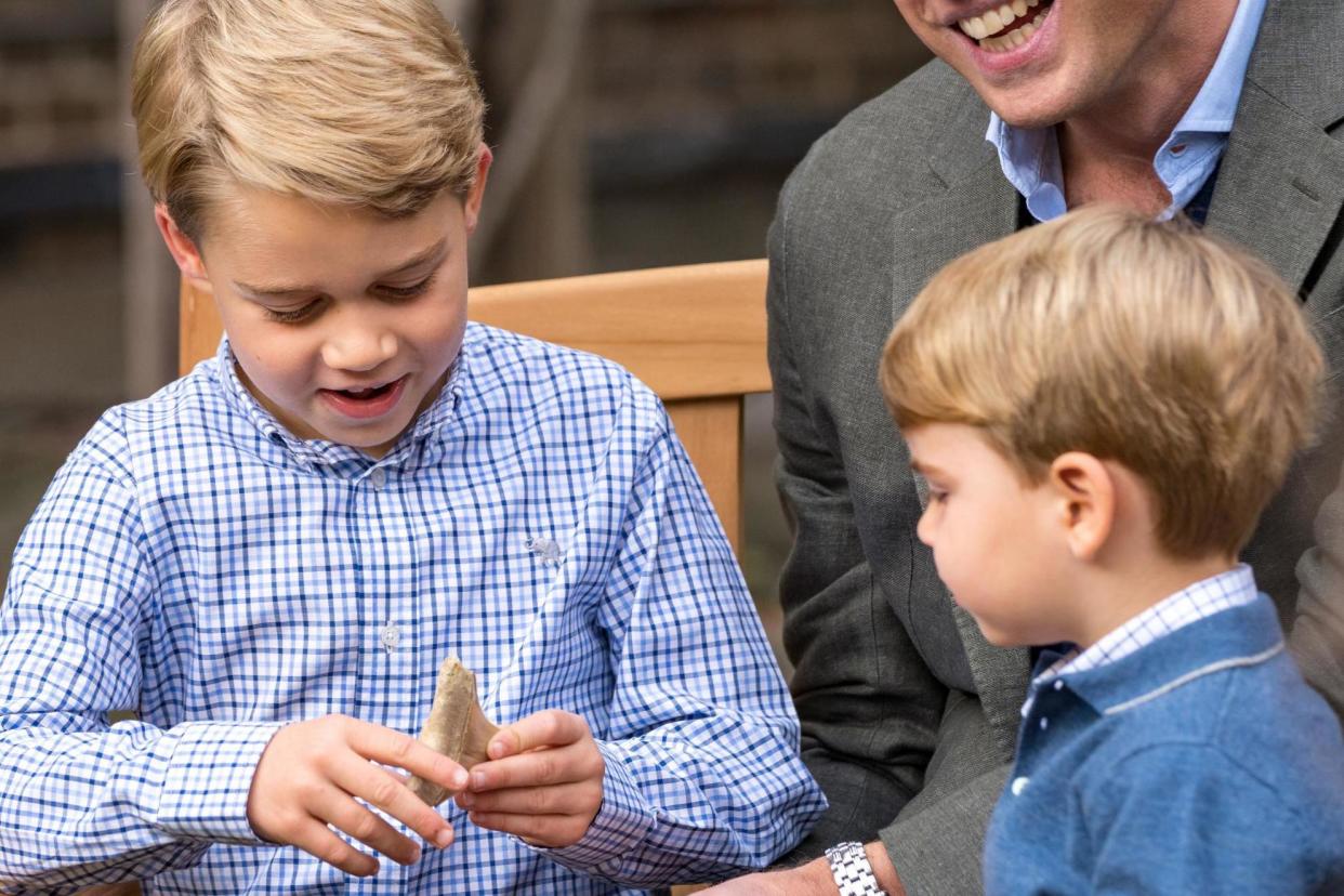 Prince George holding the giant shark tooth that was given to him by Sir David Attenborough: PA