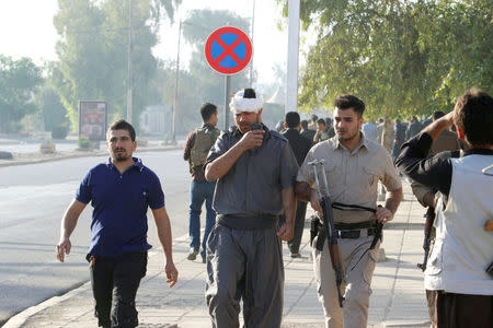 An injured Kurdish man walks at a site of an attack by Islamic State militants in Kirkuk, Iraq, October 21, 2016. REUTERS/Ako Rasheed