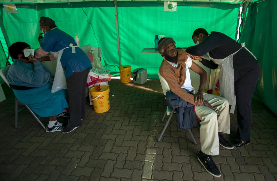 Health workers vaccinates pensioners with a first dose of the Pfizer coronavirus vaccine inside a tent during a mass vaccination program for the elderly at the clinic outside Johannesburg, South Africa, Monday, May 24, 2021. South Africa aims to vaccinate 5 million of its older citizens by the end of June. (AP Photo/Themba Hadebe)