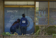 In this Jan. 9, 2020 photo, clients wait to enter the DirecTV headquarters in Caracas, Venezuela. Venezuelan President Maduro’s opponents want AT&T’s DirecTV unit to restore a number of channels it was required to take down from its lineup. But forcing AT&T to do the political bidding of Maduro’s foes could lead to retaliation and likely exit from a market where it has a whopping 44% market share. (AP Photo/Matias Delacroix)