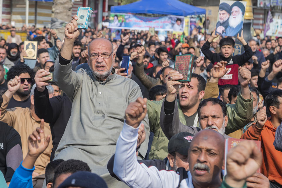 Followers of the Shiite cleric Muqtada al-Sadr raise the Quran, the Muslim holy book, in response to the burning of a copy of the Quran in Sweden, during open-air Friday prayers in Baghdad, Iraq, Friday, Jan. 27, 2023. (AP Photo/Hadi Mizban)