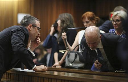 Oscar Pistorius leans towards his uncle Arnold Pistorius during his trial in the North Gauteng High Court in Pretoria, May 13, 2014. REUTERS/Themba Hadebe/Pool (
