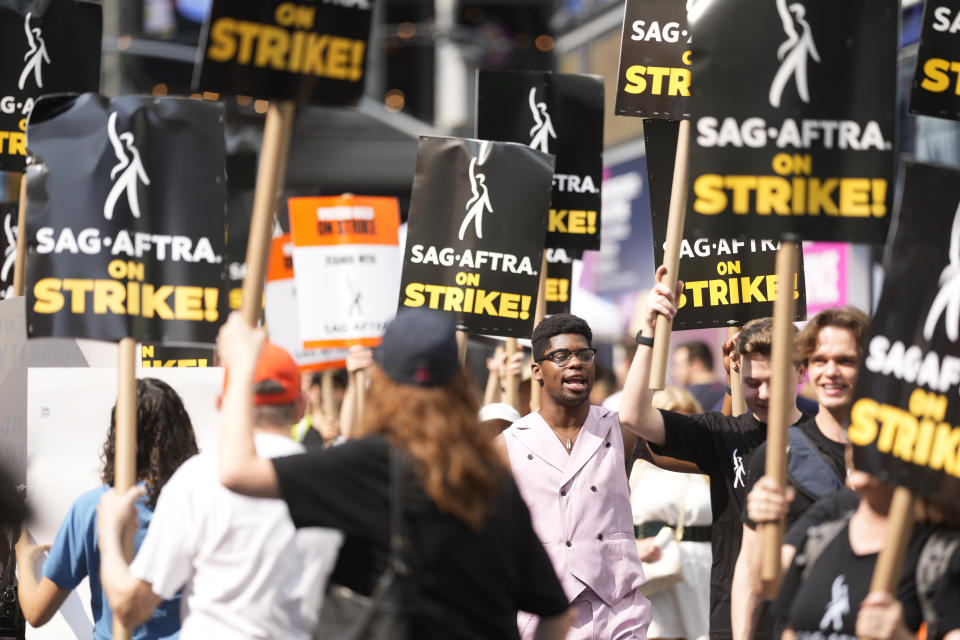 Picketers carry signs outside Paramount in Times Square on Monday, July 17, 2023, in New York. The actors strike comes more than two months after screenwriters began striking in their bid to get better pay and working conditions and have clear guidelines around the use of AI in film and television productions. (Photo by Charles Sykes/Invision/AP)