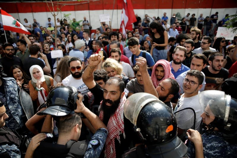 Protesters chant slogans in front of police officers as they demonstrate outside of Lebanon Central Bank during ongoing anti-government protests in Beirut