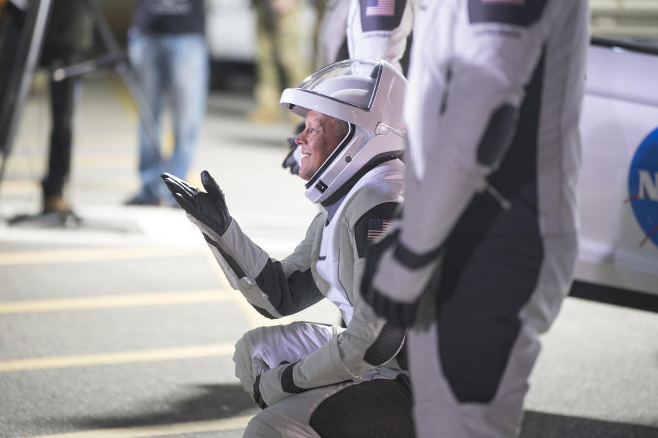 NASA astronaut Robert Hines gestures to family and friends as he and crew mates depart the Neil A. Armstrong Operations and Checkout Building for Launch Complex 39A to board the SpaceX Crew Dragon spacecraft for the Crew-4 mission launch, Tuesday, April 26, 2022, at NASA's Kennedy Space Center in Florida. (Aubrey Gemignani, NASA via AP)