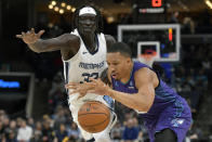 Charlotte Hornets forward Grant Williams drives against Memphis Grizzlies forward Wenyen Gabriel (32) during the first half of an NBA basketball game Wednesday, March 13, 2024, in Memphis, Tenn. (AP Photo/Brandon Dill)