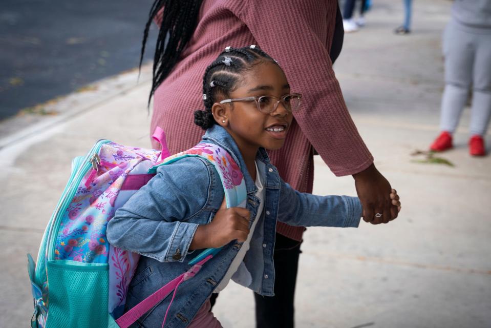 First grader Jaymee Parish, 6, is escorted by her mother to her first day of school at Eisenhower Elementary School in Southfield on Monday, Aug. 28, 2023.