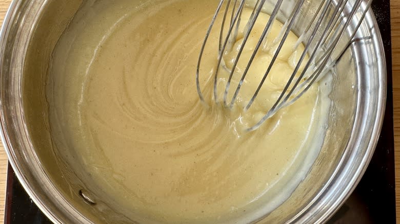 whisking pot of white chocolate ganache