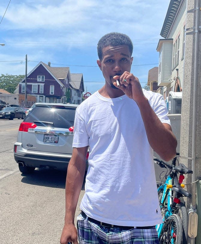 Brandon Greer smokes a cigarette at the Juneteenth Day festivities on the north side. He is trying to stop.