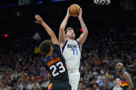 Dallas Mavericks guard Luka Doncic (77) shoots over Phoenix Suns forward Cameron Johnson (23) during the second half of Game 7 of an NBA basketball Western Conference playoff semifinal, Sunday, May 15, 2022, in Phoenix. The Mavericks defeated the Suns 123-90. (AP Photo/Matt York)