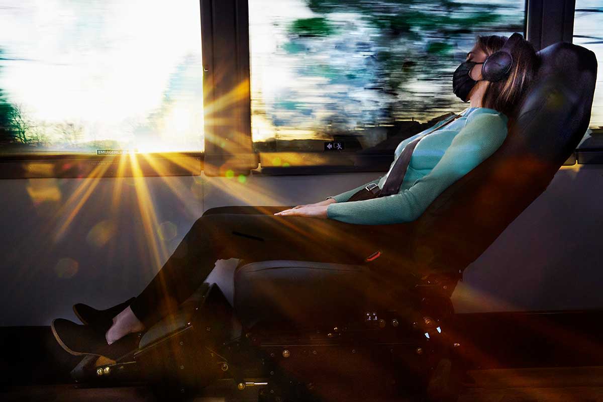 A woman sleeping on a reclining chair on The Jet, a new luxury bus line