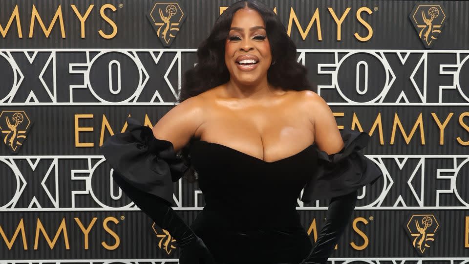 Niecy Nash, nominated for her performance in “Monster: The Jeffrey Dahmer Story,” wore a custom Greta Constantine velvet and satin mermaid dress with voluminous ruffled sleeves and flounce hem. She completed the look with a pair of matching opera gloves. - Aude Guerrucci/Reuters