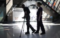 22-year-old Errol Samuels from Queens, New York, who lost the use of his legs in 2012 after a roof collapsed onto him at an off-campus house party near where he was attending college in upstate New York, walks with a ReWalk electric powered exoskeletal suit during a therapy session with Alexandra Voigt, a clinical research coordinator and therapist, at the Mount Sinai Medical Center in New York City March 26, 2014. Made by the Israeli company Argo Medical Technologies, ReWalk is a computer controlled device that powers the hips and knees to help those with lower limb disabilities and paralysis to walk upright using crutches. Allan Kozlowski, assistant professor of Rehabilitation Medicine at Icahn School of Medicine at Mount Sinai hospital, where patients like Samuels are enrolled in his clinical trials of the ReWalk and another exoskeleton, the Ekso (Ekso Bionics) hopes machines like these will soon offer victims of paralysis new hope for a dramatically improved quality of life and mobility. The ReWalk is currently only approved by the U.S. Food and Drug Administration (FDA) for use in rehabilitation facilities like at Mount Sinai, as they weigh whether to approve the device for home use as it already is in Europe. Picture taken March 26, 2014. REUTERS/Mike Segar