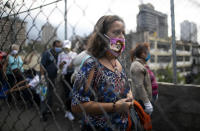 A woman wears a home made mask, with an image of a Disney princess, as a precaution amid the spread of the new coronavirus as she lines up to buy food in Caracas, Venezuela, Thursday, April 2, 2020. (AP Photo/Ariana Cubillos)