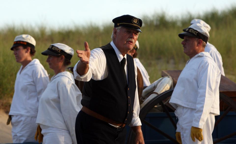 David Spang of North Truro (black vest) in his role as Hezekiah Doane, keeper of the Old Harbor Life-Saving Station in 1902, during a Beach Apparatus Drill in 2015.